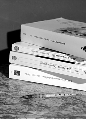 Photo en noir et blanc d'une pile de livre.