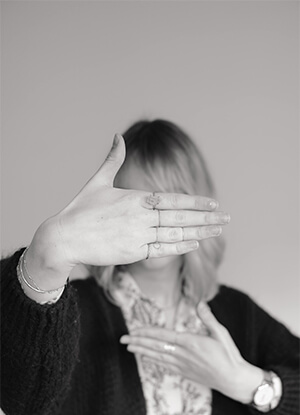 Photo en noir et blanc de Ayla avec sa main devant le visage.