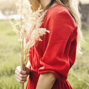 Photo d'une femme dans un champ avec un bouquet de pampas.